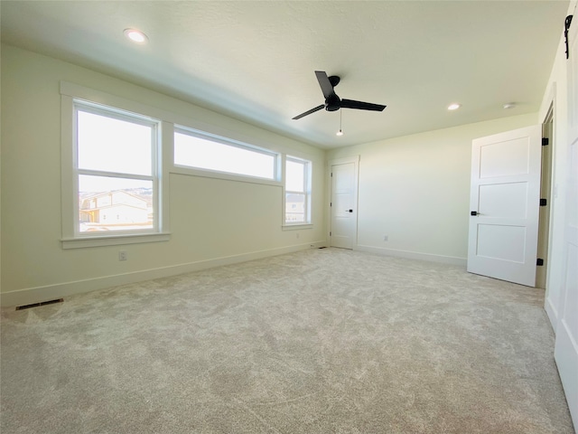 empty room with baseboards, recessed lighting, visible vents, and light colored carpet