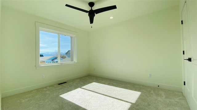 unfurnished bedroom featuring light carpet, a ceiling fan, visible vents, and baseboards