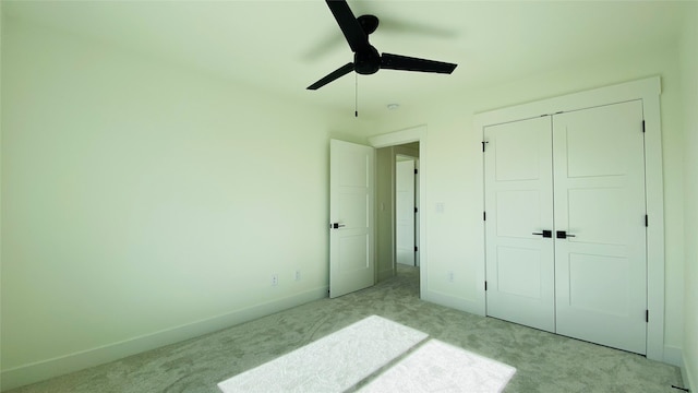 bedroom with light carpet, ceiling fan, baseboards, and a closet