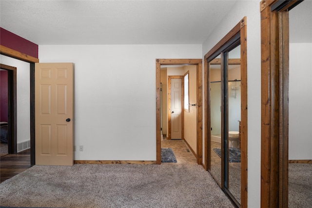 unfurnished bedroom with carpet floors, visible vents, and baseboards