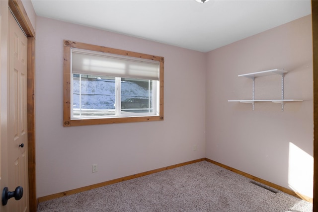 carpeted empty room with baseboards and visible vents