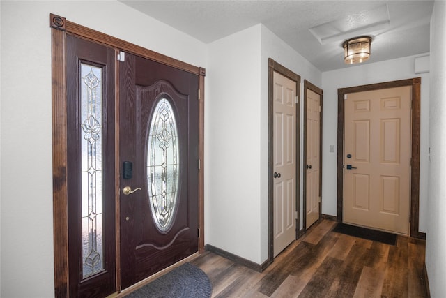 foyer entrance featuring dark wood-type flooring and baseboards