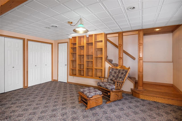 sitting room with stairs, carpet floors, and baseboards