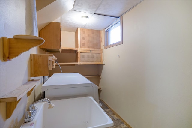 clothes washing area with washer / clothes dryer, laundry area, and a sink