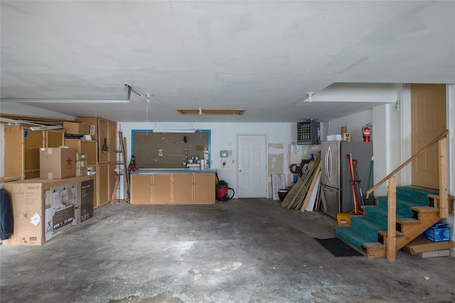 garage featuring a workshop area and freestanding refrigerator