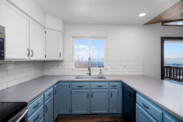 kitchen featuring blue cabinets, white cabinets, a sink, and dishwasher