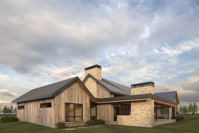 exterior space featuring a standing seam roof, metal roof, a yard, and a chimney