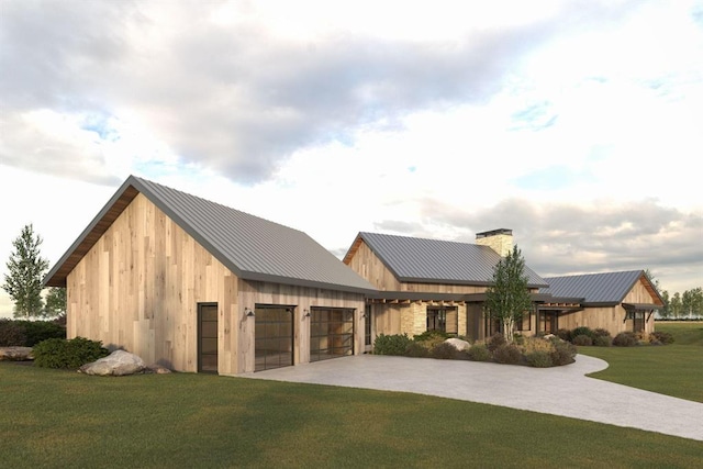 view of front of house featuring an attached garage, a front yard, a standing seam roof, metal roof, and driveway