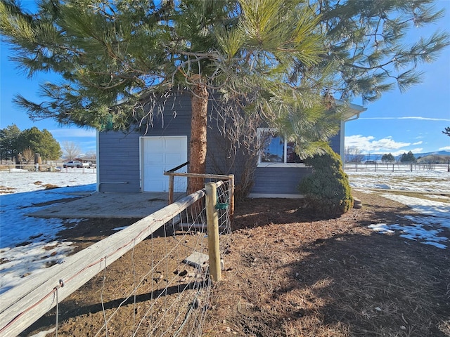 view of property exterior featuring a garage and fence