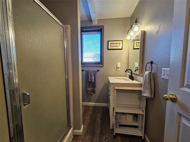 full bath featuring a shower stall, baseboards, wood finished floors, and vanity