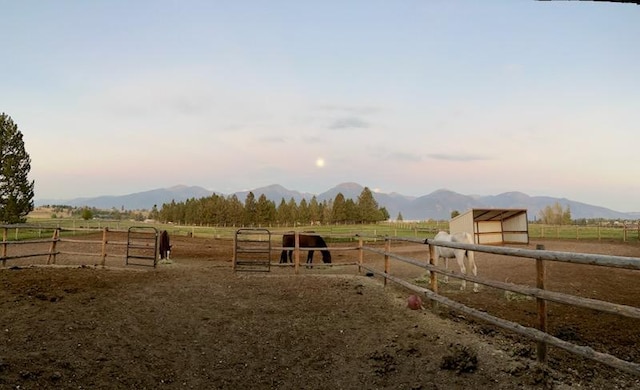 view of yard with a mountain view, an exterior structure, and a rural view