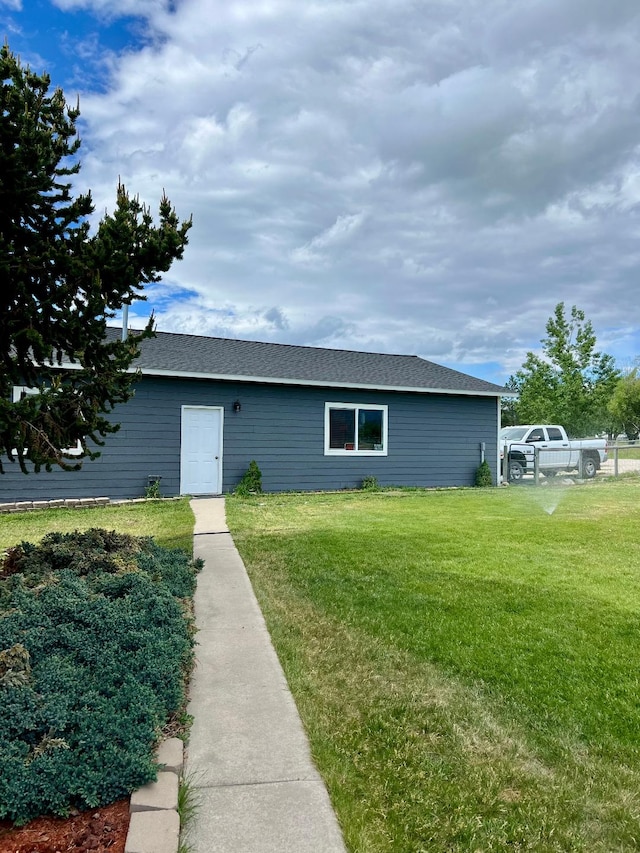 view of front of property with a front lawn and a shingled roof