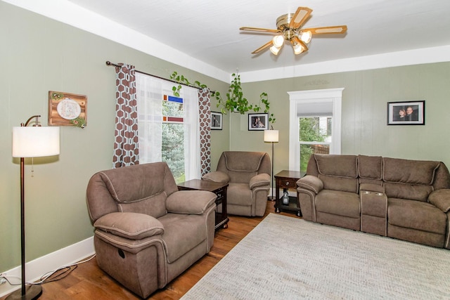 living room featuring ceiling fan, baseboards, and wood finished floors