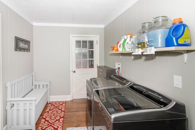 laundry area with laundry area, washing machine and dryer, crown molding, and wood finished floors