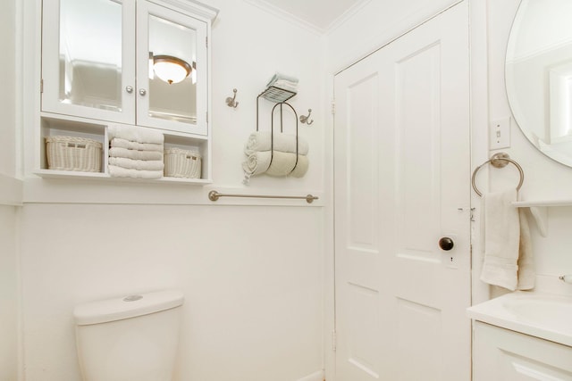 bathroom with crown molding, vanity, and toilet