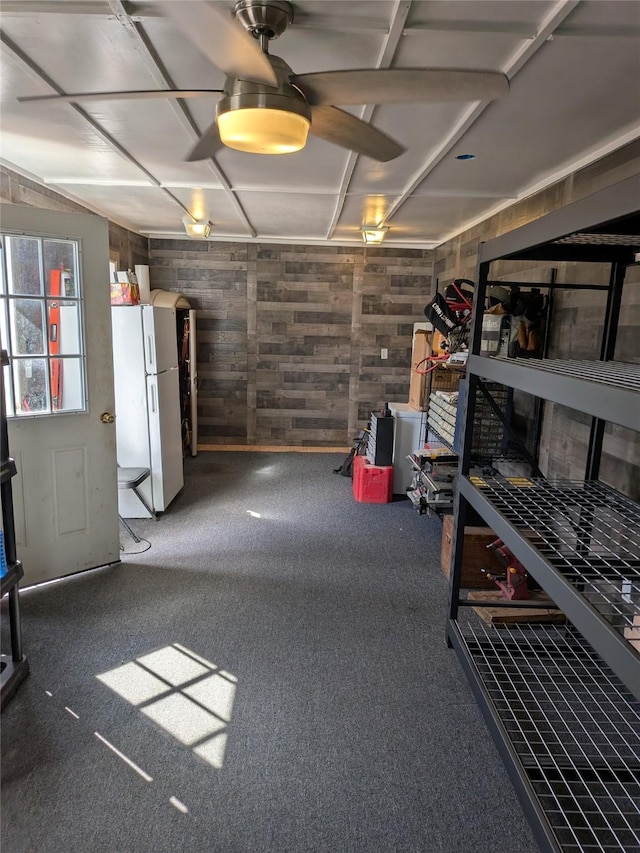 interior space featuring freestanding refrigerator and wood walls