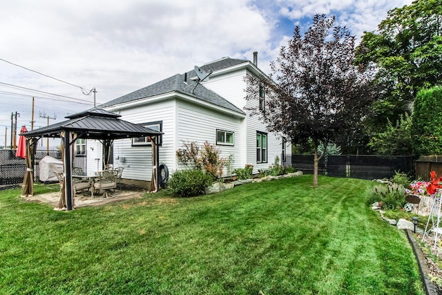 back of property with a patio area, a fenced backyard, a yard, and a gazebo