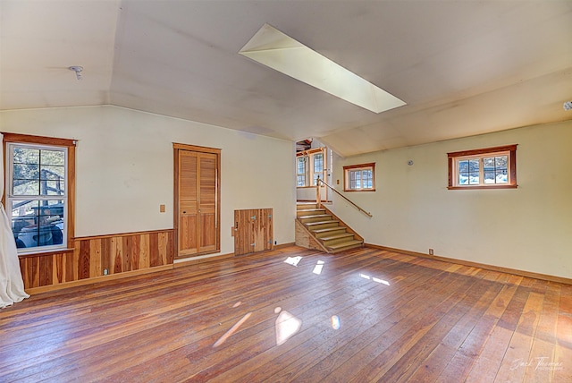 6220 Elkhorn Rd, Helena, MT 59602 - unfurnished living room featuring plenty of natural light, vaulted ceiling with skylight, and hardwood / wood-style flooring