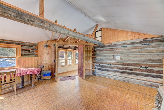 interior space featuring high vaulted ceiling, rustic walls, and beamed ceiling