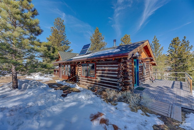 6220 Elkhorn Rd, Helena, MT 59602 - snow covered property with a wooden deck, solar panels, and log exterior