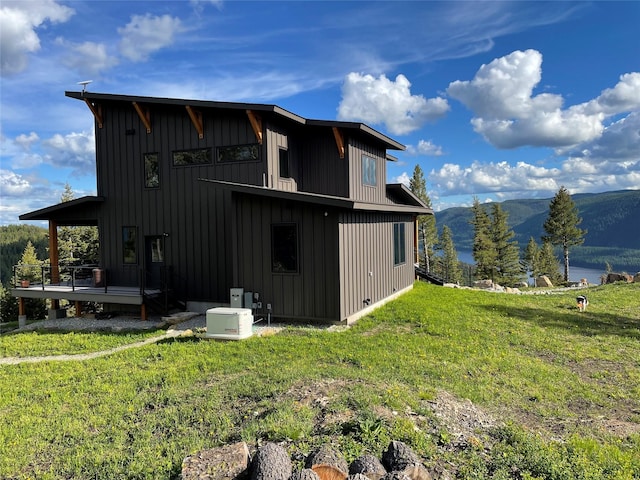 75 Meadows Dr, Whitefish, MT 59937 - rear view of house featuring a lawn, board and batten siding, and a mountain view