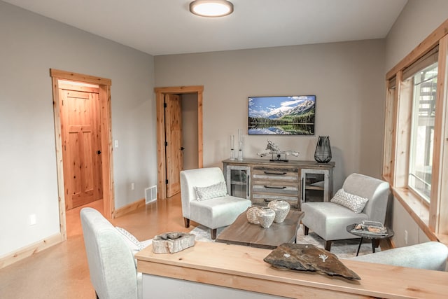 living area featuring baseboards and visible vents