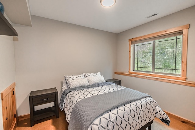 carpeted bedroom featuring visible vents and baseboards