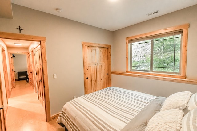 bedroom with visible vents, light carpet, and baseboards