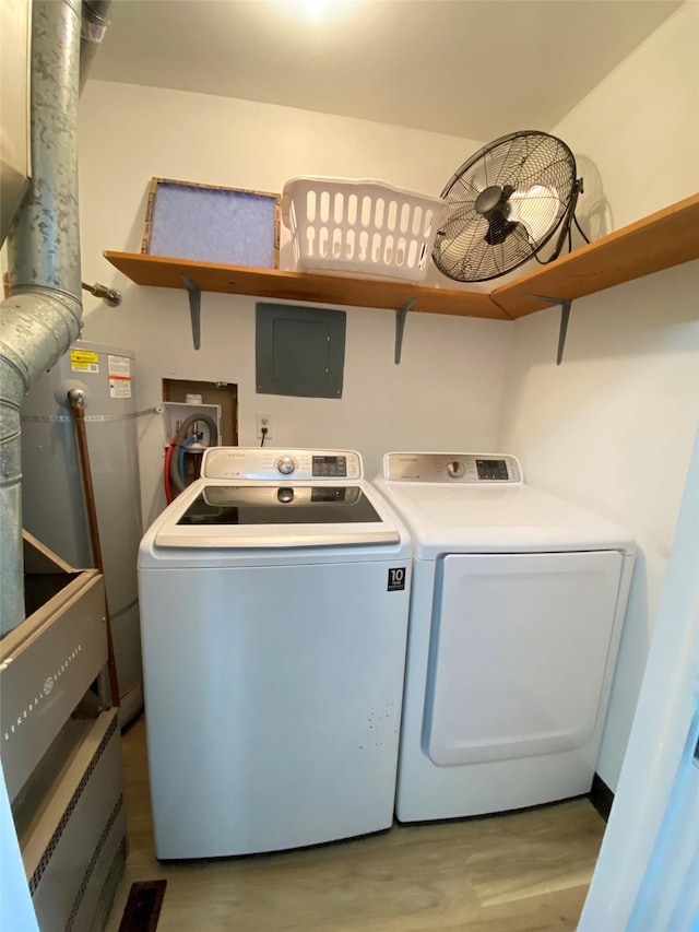 clothes washing area featuring laundry area, water heater, independent washer and dryer, and light wood finished floors