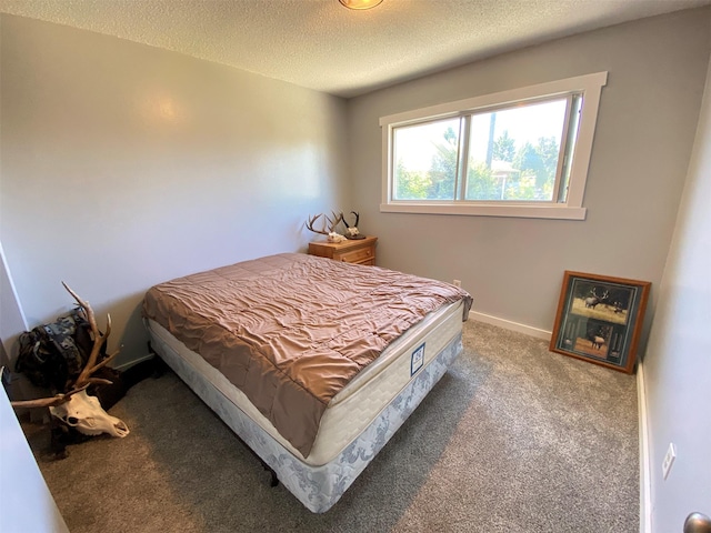 carpeted bedroom featuring a textured ceiling and baseboards