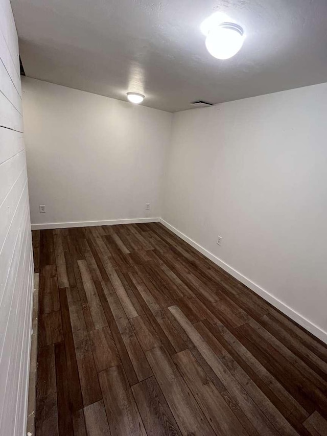 finished basement featuring dark wood-style flooring and baseboards