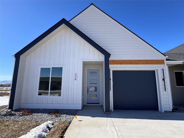 view of front of property with board and batten siding, concrete driveway, roof with shingles, and an attached garage