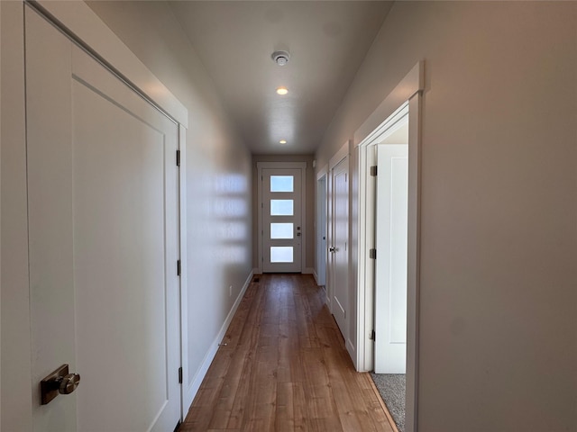 corridor with light wood-style floors, recessed lighting, and baseboards