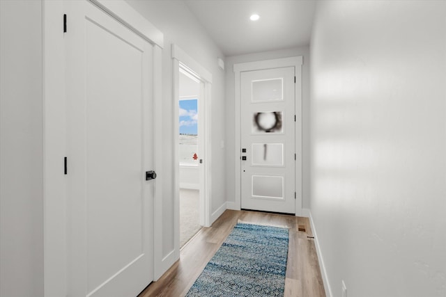 doorway featuring light wood-style flooring, baseboards, and recessed lighting