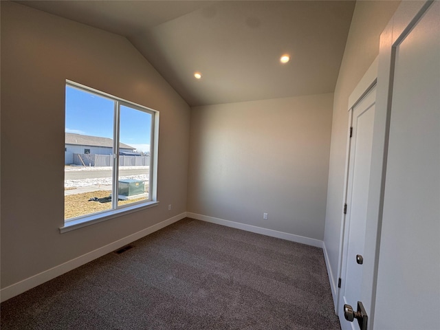 empty room featuring recessed lighting, visible vents, baseboards, vaulted ceiling, and dark carpet