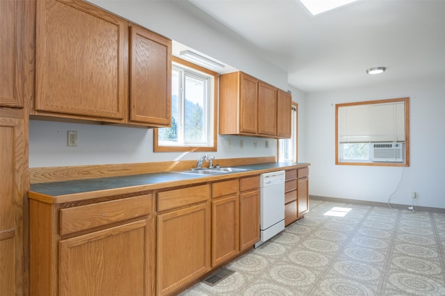 kitchen featuring visible vents, a sink, cooling unit, dishwasher, and baseboards