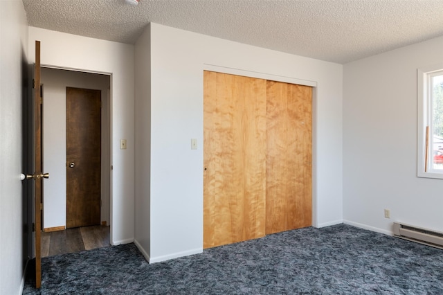 unfurnished bedroom with a baseboard radiator, a textured ceiling, baseboards, and carpet flooring