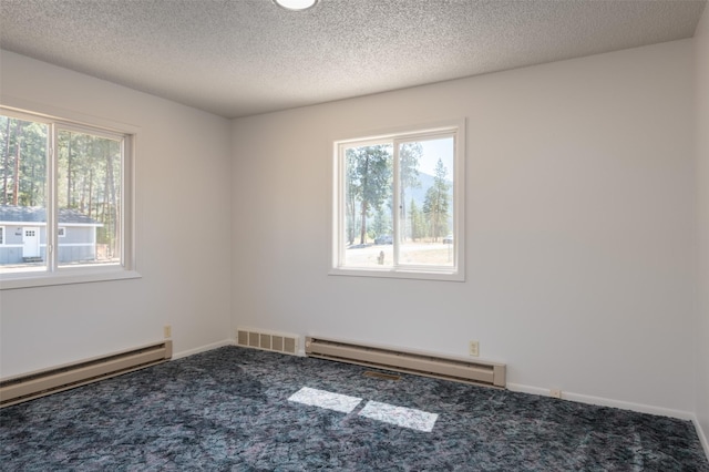 carpeted empty room with baseboard heating, visible vents, and a healthy amount of sunlight