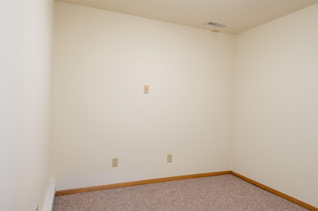 spare room with baseboards, visible vents, and light colored carpet