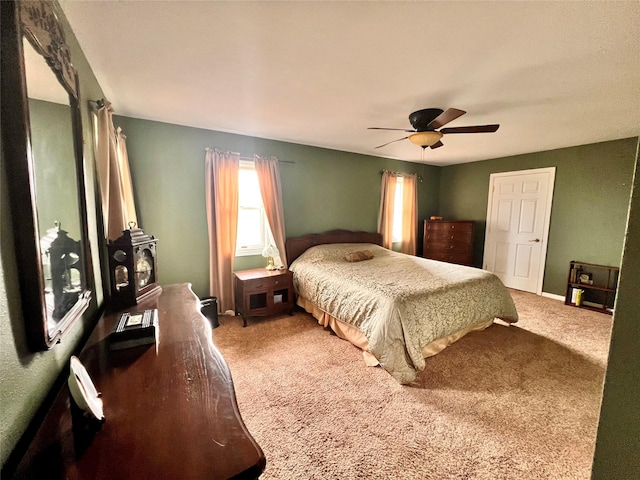 bedroom featuring carpet flooring, baseboards, a wood stove, and ceiling fan