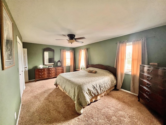 bedroom featuring baseboards, multiple windows, carpet, and a ceiling fan