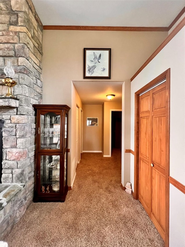 corridor with carpet flooring, baseboards, and ornamental molding