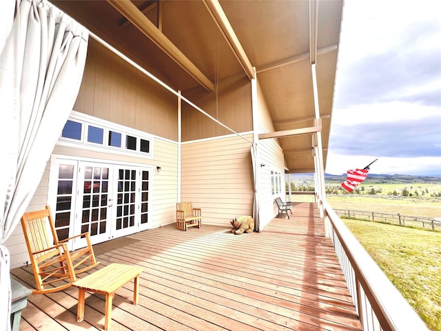 wooden terrace with a rural view, french doors, and fence