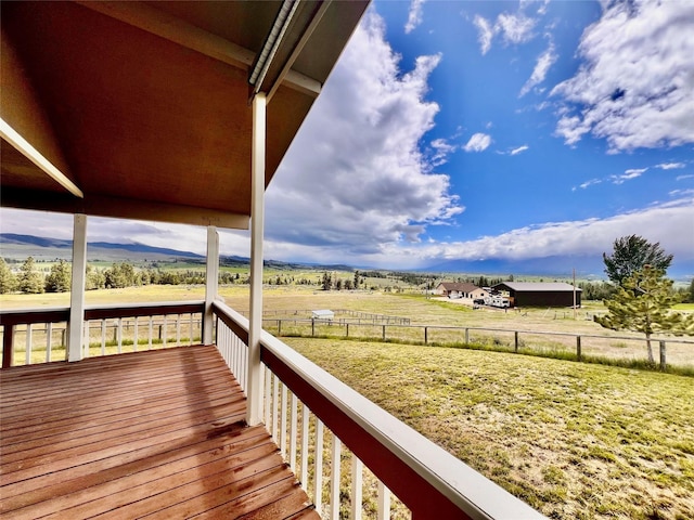 wooden terrace with a rural view and fence