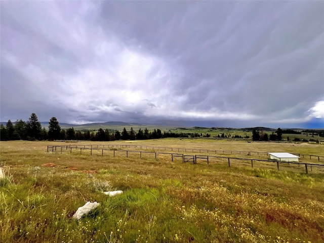 view of yard with a rural view and fence