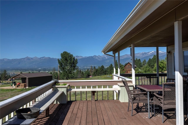 wooden deck featuring a mountain view and outdoor dining area