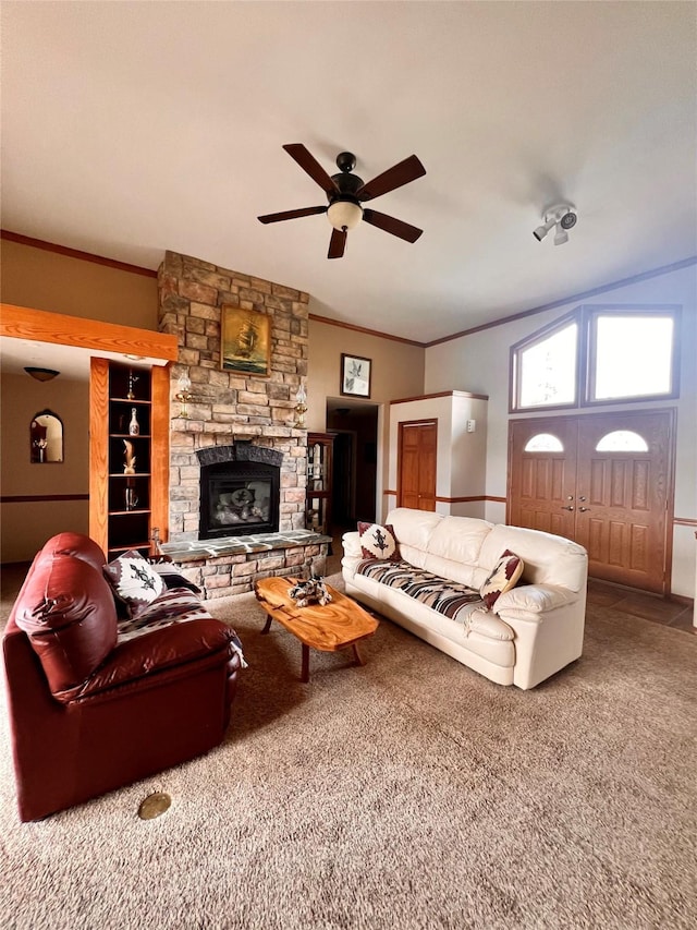 carpeted living room featuring a stone fireplace, crown molding, a ceiling fan, and lofted ceiling