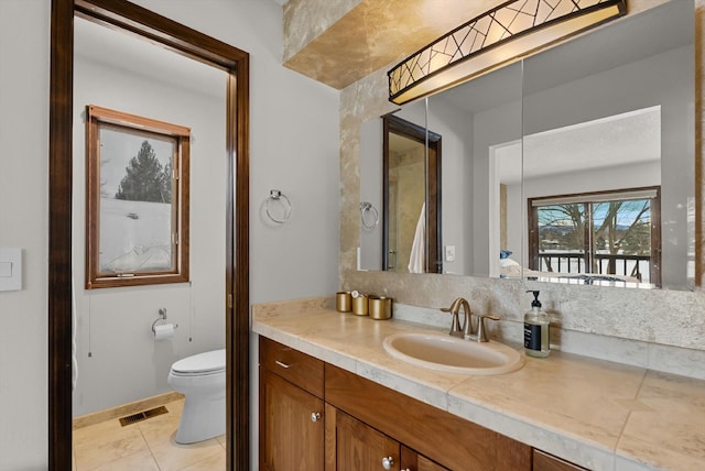 bathroom featuring visible vents, vanity, toilet, and tile patterned floors