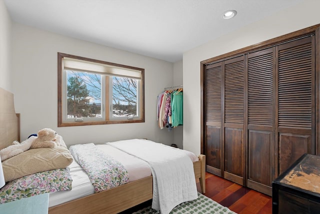 bedroom with dark wood-type flooring, a closet, and recessed lighting