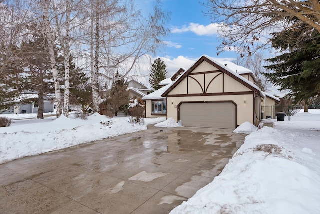 view of front facade with an attached garage, driveway, and stucco siding